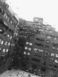 City seen through wet glass window during rainy season
