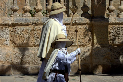 People in traditional clothing walking on street during easter