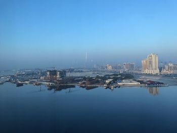 City at waterfront against clear sky