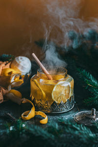 Autumn or winter hot tea with lemon and sugar with steam above the cup on a dark background