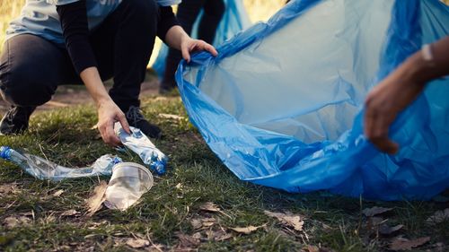 Low section of man cleaning garbage