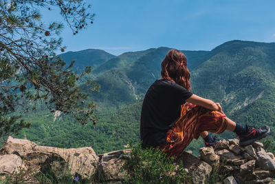 Man sitting on mountain looking at mountains