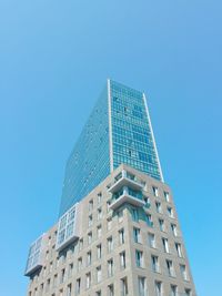 Low angle view of modern building against clear blue sky