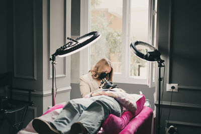 Tattoo artist making tattoo on woman face