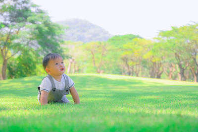 Cute boy looking away on field