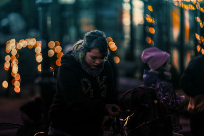 Woman looking at illuminated city at night