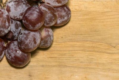 High angle view of grapes on wooden table