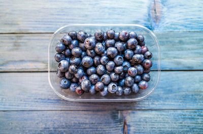 Directly above shot of blackberries in container on table