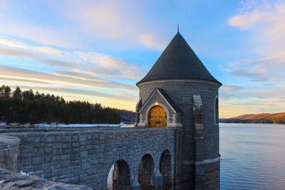 Historic building in lake against blue sky