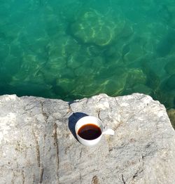 High angle view of coffee cup on rock