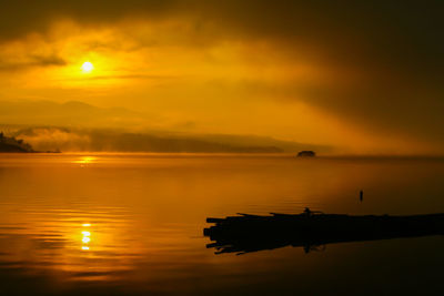 Scenic view of sea against orange sky