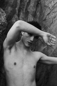 Young male with  androgynous look shot outdoor in black and white with rocks in background.