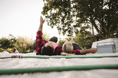 Man with arms raised resting by partner after renovating during summer