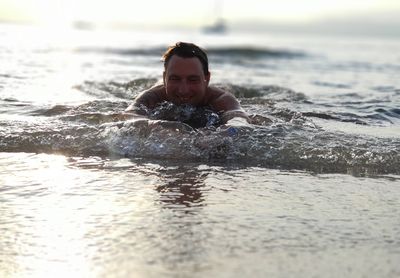 Smiling man swimming in sea