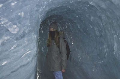 Woman standing in glacier during winter