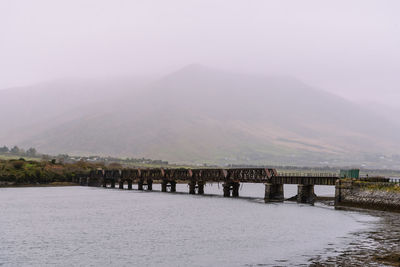 Scenic view of river by mountains against sky