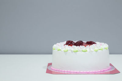 Close-up of cake on table against white background