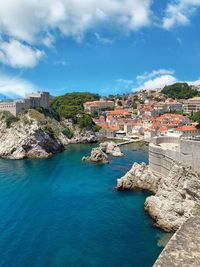 High angle view of townscape by sea against sky