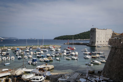 High angle view of boats moored at harbor against sky