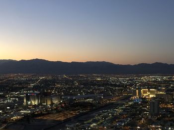 High angle view of illuminated city against sky at night