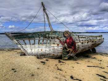 Portrait of man on boat at beach against sky