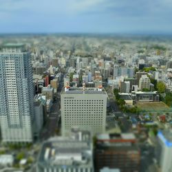 Tilt-shift image of cityscape against sky