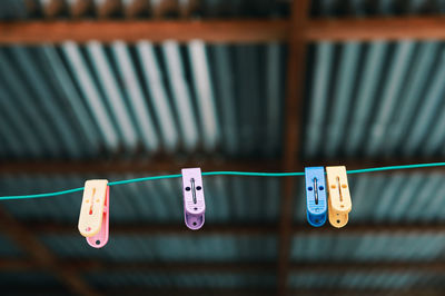 Close-up of clothespins hanging on rope