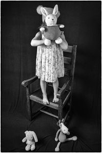 Portrait of cute girl with toy standing at home