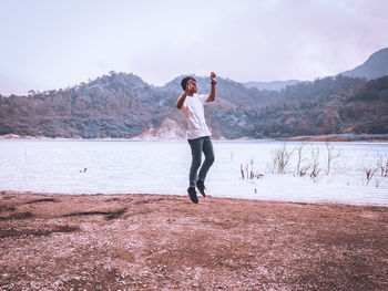 Full length of young woman standing in water