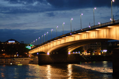 Illuminated bridge over river against sky at night