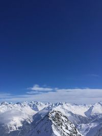 Scenic view of snowcapped mountains against blue sky