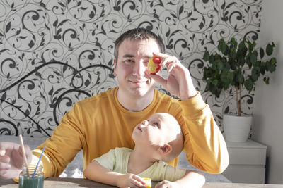 Dad with a child a little boy are preparing for easter, painting eggs, having lunch and having fun.