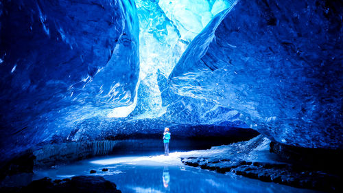 Scenic view of waterfall against sky seen through cave