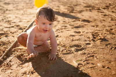 Boy looking away on sand at beach