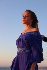 Rear view of woman looking away against clear sky