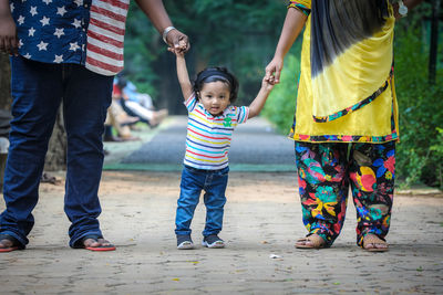 Low section of parents with baby boy in park