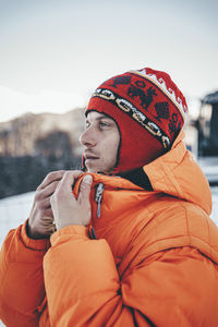Man wearing knit hat and jacket looking away