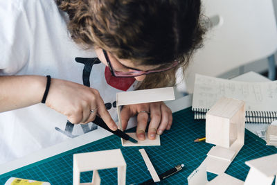 Close-up of young woman working with cardboard on table