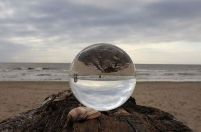 Water on beach by sea against sky