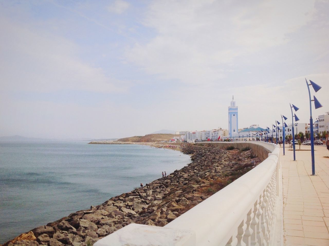 water, architecture, built structure, sea, building exterior, sky, tower, city, travel destinations, tourism, cloud, footpath, famous place, walkway, tall - high, international landmark, coastline, day, distant, outdoors, shore, scenics, cloud - sky, capital cities