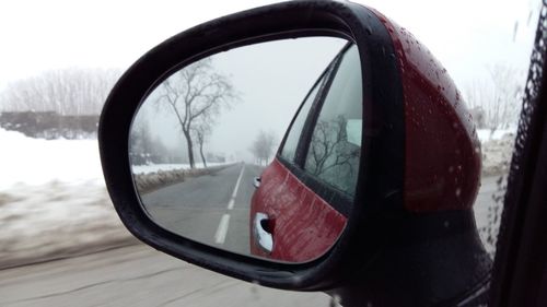 Close-up of reflection of car on side-view mirror