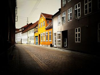 Empty alley amidst buildings in city