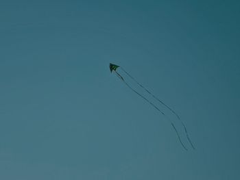 Low angle view of birds flying against blue sky