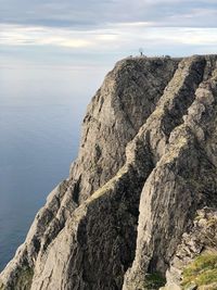 Rock formations by sea against sky