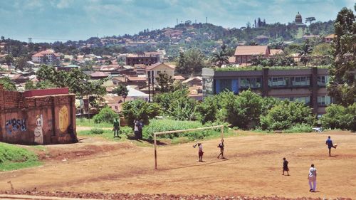 People playing soccer against sky