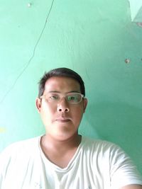 Portrait of young man against wall