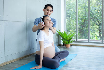 Father is opening music for pregnant mother to relax mother and baby.