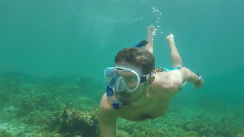 Shirtless young man snorkeling in sea