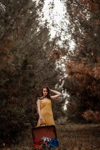 Woman standing by tree in forest