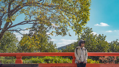 Portrait of woman standing against trees